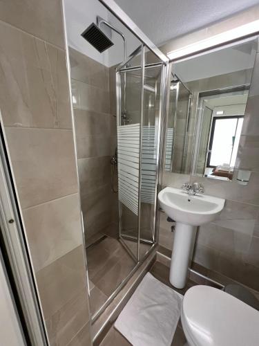 a bathroom with a shower and a toilet and a sink at Sun's Suites in Asprovalta