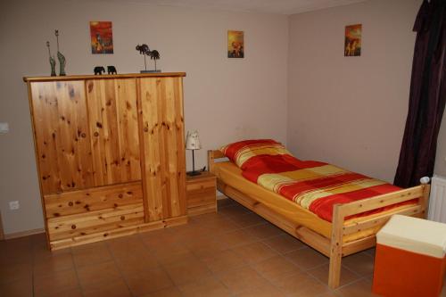 Schlafzimmer mit einem Bett und einem Holzschrank in der Unterkunft Ferienwohnung Peerenboomshof in Kranenburg