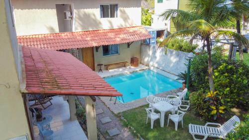 balcón con piscina, mesa y sillas en Vila Ebert, en Niterói