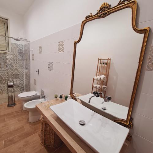a bathroom with a white sink and a mirror at A un Passo dal Tramonto in Marsala