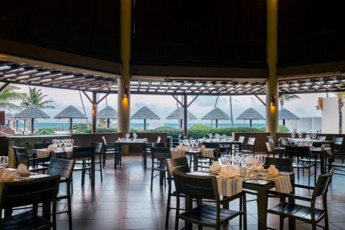 a dining room with tables and chairs with a view of the ocean at Iberostar Waves Bahia - All Inclusive in Praia do Forte