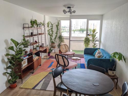 uma sala de estar com um sofá azul e uma mesa e cadeiras em Appartement 3 pièces avec parking couvert gratuit. em Le Pré-Saint-Gervais