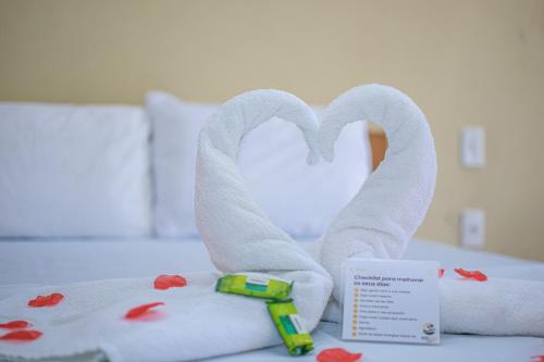 a bed with towels and a toy in the shape of a heart at Hotel Preá in Prea