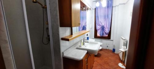 y baño con lavabo blanco y espejo. en Appartamento comodo per Lerici e 5 Terre, en Piano di Follo