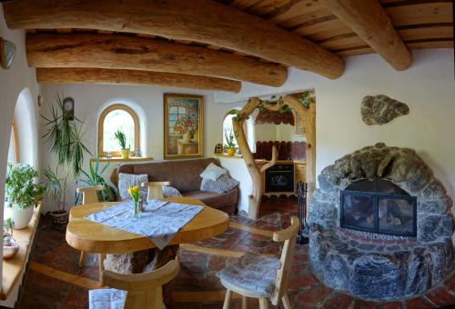 sala de estar con mesa y chimenea de piedra en Natur apartma Rudi, en Begunje na Gorenjskem