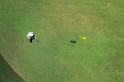 a person is flying a kite in a field at Iberostar Waves Bahia - All Inclusive in Praia do Forte