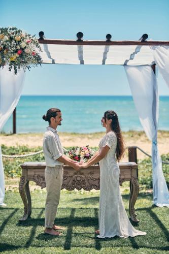 a bride and groom standing under a ceremony altar at Iberostar Waves Bahia - All Inclusive in Praia do Forte