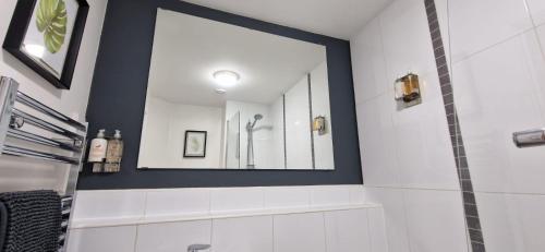een badkamer met een spiegel en een douche bij The Property Parlour in Reading