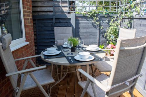 een patio tafel en stoelen op een balkon met een tafel en stoelen bij 121 Studio - Central Studio Apartment, Terrace & Full Kitchen - Airport & Train Shuttle in Bishops Stortford