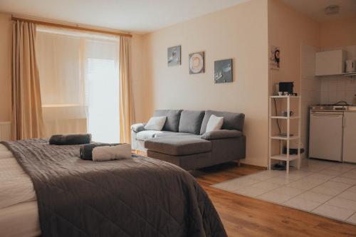 a living room with a bed and a couch at Casa Galliera - Apartment in Keszthely