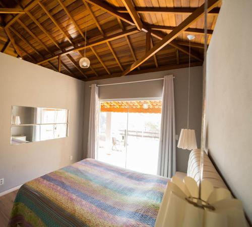 1 dormitorio con cama y ventana en Casa de campo com piscina cascata artificial, en São Lourenço