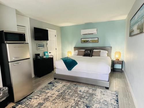 a bedroom with a bed and a refrigerator at 1915 Beach Club in Daytona Beach