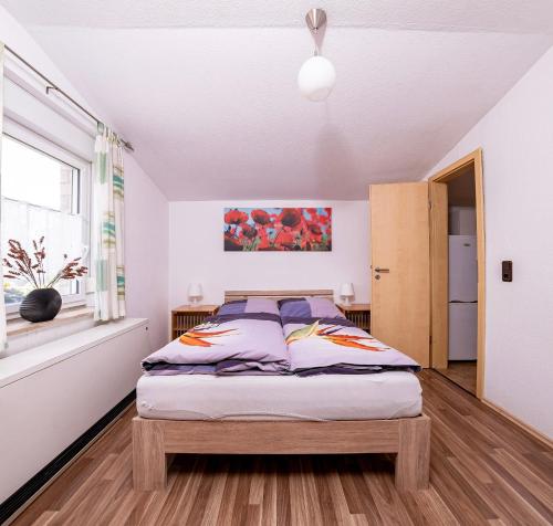 sypialnia z łóżkiem i oknem w obiekcie Ferienwohnung Leipzig- Hirschfeld Apartments w Lipsku