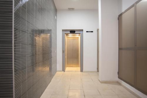 ein Flur mit einer Tür und einem Fliesenboden in der Unterkunft Nuevo y moderno apartamento con aire acondicionado - El Cid 4 in Burriana