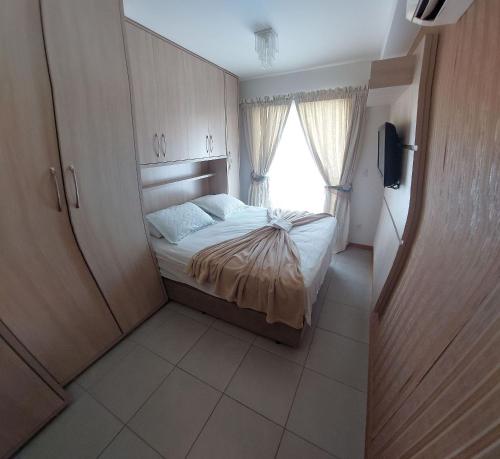 Habitación pequeña con cama y ventana en Nautilus Apartment Vista Mar, en Penha