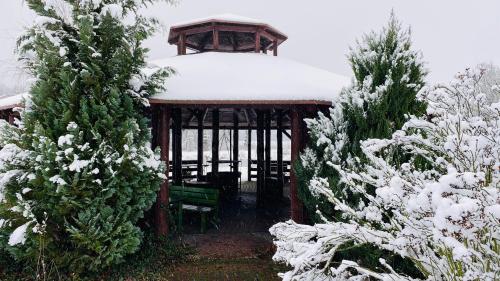 a gazebo with a bench in the snow at Gospodarstwo Agroturystyczne Zasadkowe Bory in Rogowo