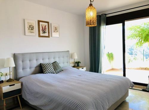 a bedroom with a bed and a large window at Albatros Golf View 2394 in Casares