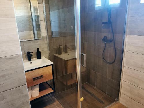 uma casa de banho com um chuveiro e um lavatório. em Gościniec Mariola em Człuchów