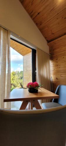 een houten tafel met een vaas met bloemen erop bij Hotel Pico 16 in Monte Verde