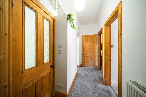 a hallway with an open wooden door and windows at The Palais in Dundee
