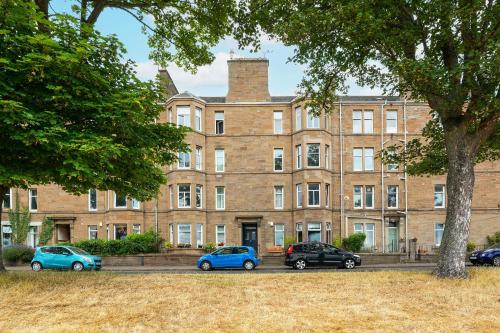 a large brick building with cars parked in front of it at The Palais in Dundee