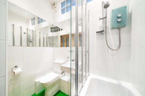 een badkamer met een douche, een toilet en een wastafel bij The Palais in Dundee