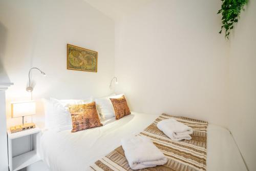 a white bedroom with a bed with pillows at The Palais in Dundee