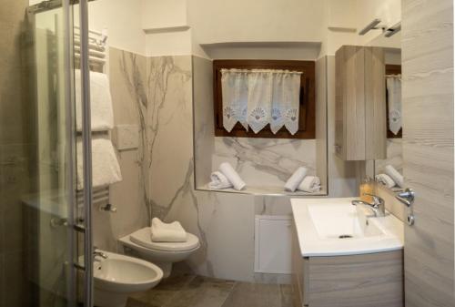 Residenza Cotruta Spiazzo في سبياتزو: حمام مع حوض ومرحاض ومرآة