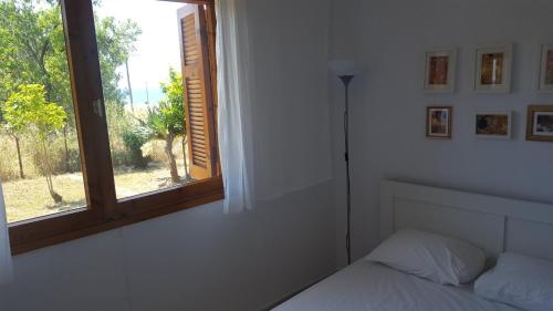 a bedroom with a bed and a window at Daddy’s sea view house in Nea Irakleia