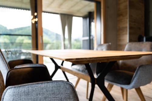 a wooden table in a room with chairs at Merlrose Apartments in Sankt Kanzian