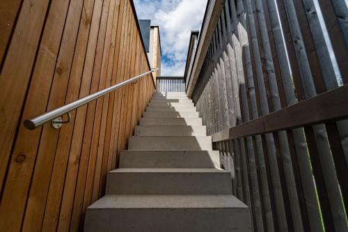 a staircase with a wooden fence and a stair railing at Merlrose Apartments in Sankt Kanzian