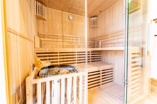 a walk in closet with wooden walls and a glass door at Merlrose Apartments in Sankt Kanzian