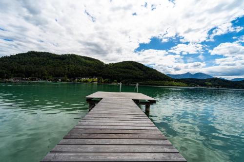 a wooden dock in the middle of a lake at Merlrose Apartments in Sankt Kanzian