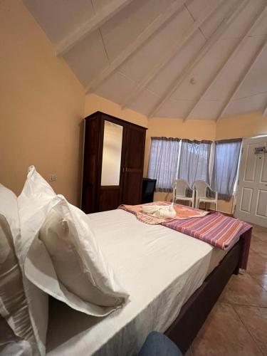 a bedroom with a large bed with two chairs at Tropic Garden Hotel in Bathurst