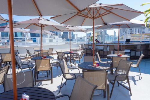 a patio area with tables, chairs and umbrellas at Casa Nova Hotel in Rio de Janeiro