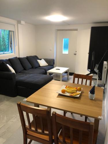 a living room with a table and a black couch at A Beautiful one bedroom apartment in Stockholm