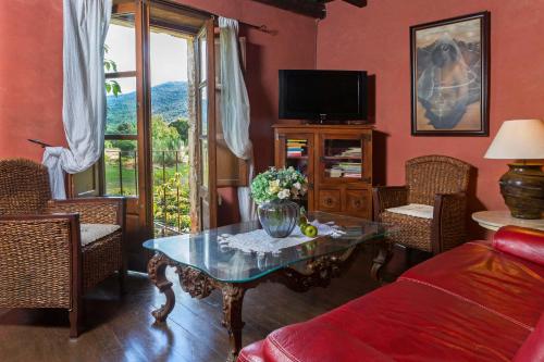 a living room with a table and a tv at Casa rural Can Jepet in La Cellera de Ter