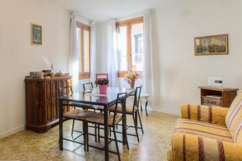 a living room with a table and chairs and a couch at Residenza de l'Osmarin Suites in Venice