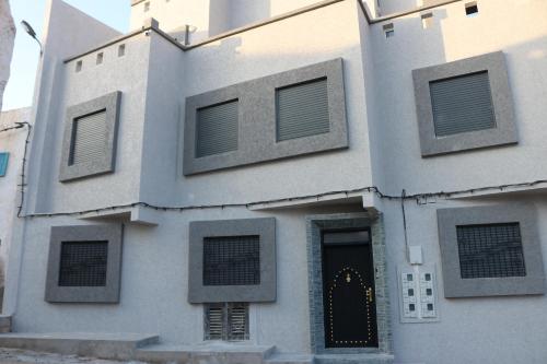 un edificio blanco con ventanas y una puerta en Tiwaline Tarsime App A, en Sidi Ifni
