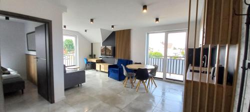ein Wohnzimmer mit einem Tisch und blauen Stühlen in der Unterkunft Apart Family in Łeba
