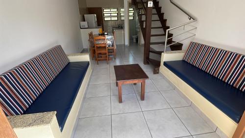 a living room with two benches and a table at Pousada Ilha Vitoria in Ubatuba