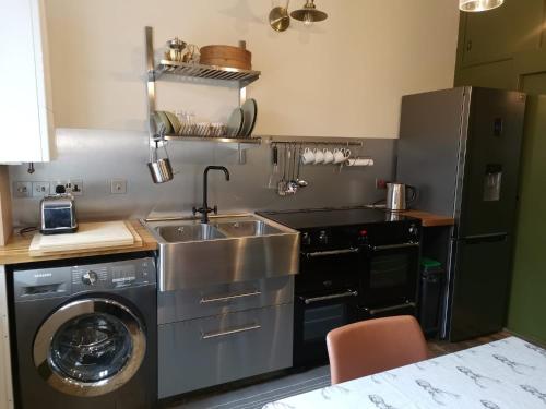 a kitchen with a sink and a washing machine at 2 bed flat in Moray, near coast and Whisky Trail in Keith