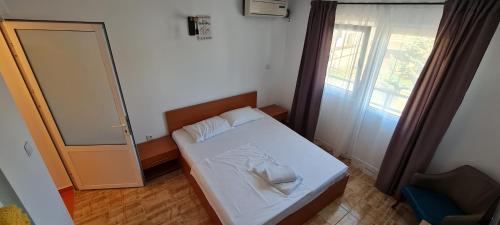 a small bedroom with a bed and a window at LaNoi LaVoi in Mangalia