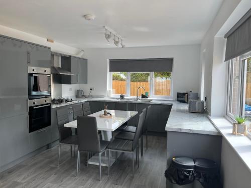 a kitchen with a table and chairs in a kitchen at House - Sleeps 14 onsite parking & pets allowed in Poole