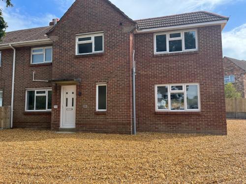 a red brick house with a white door at House - Sleeps 14 onsite parking & pets allowed in Poole
