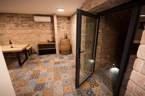 a room with a barrel and a table and a glass door at Sklep Mozajka in Velké Bílovice