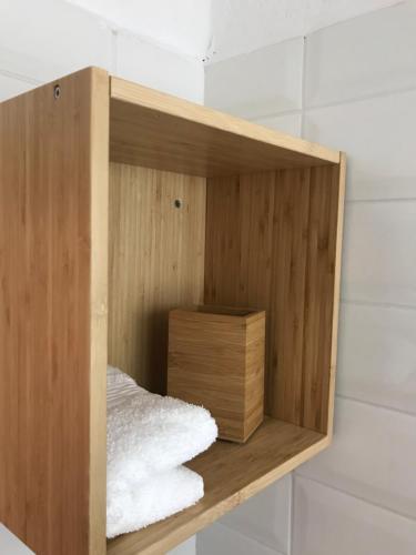 a wooden shelf with a box in a room at Irini’s Attic in Nea Iraklia