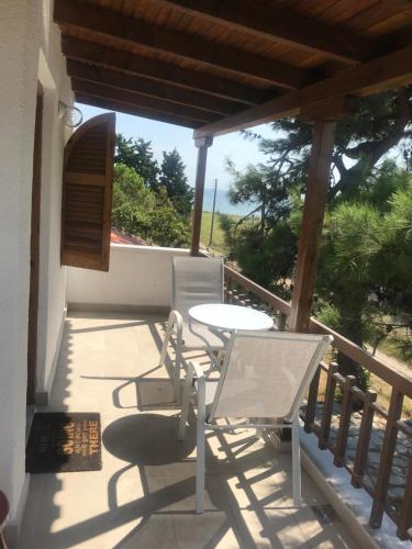a patio with a table and chairs on a balcony at Irini’s Attic in Nea Iraklia