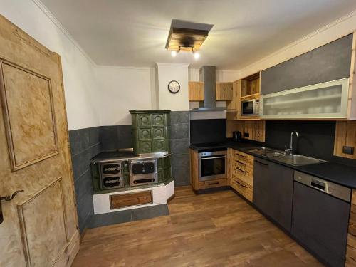 a kitchen with wooden cabinets and a green stove top oven at Ferienwohnung Rohrmoser mit 2 Schlafzimmern in Hüttschlag