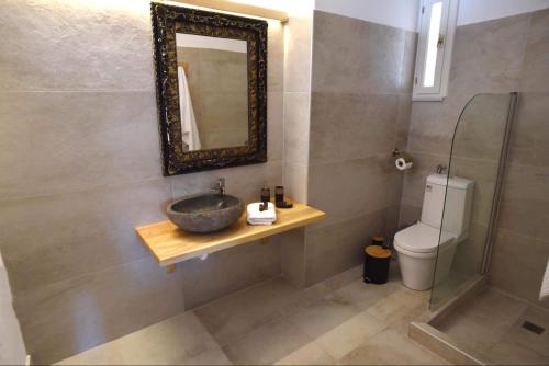 een badkamer met een wastafel, een toilet en een spiegel bij Zoe apartment in Galaxidhion